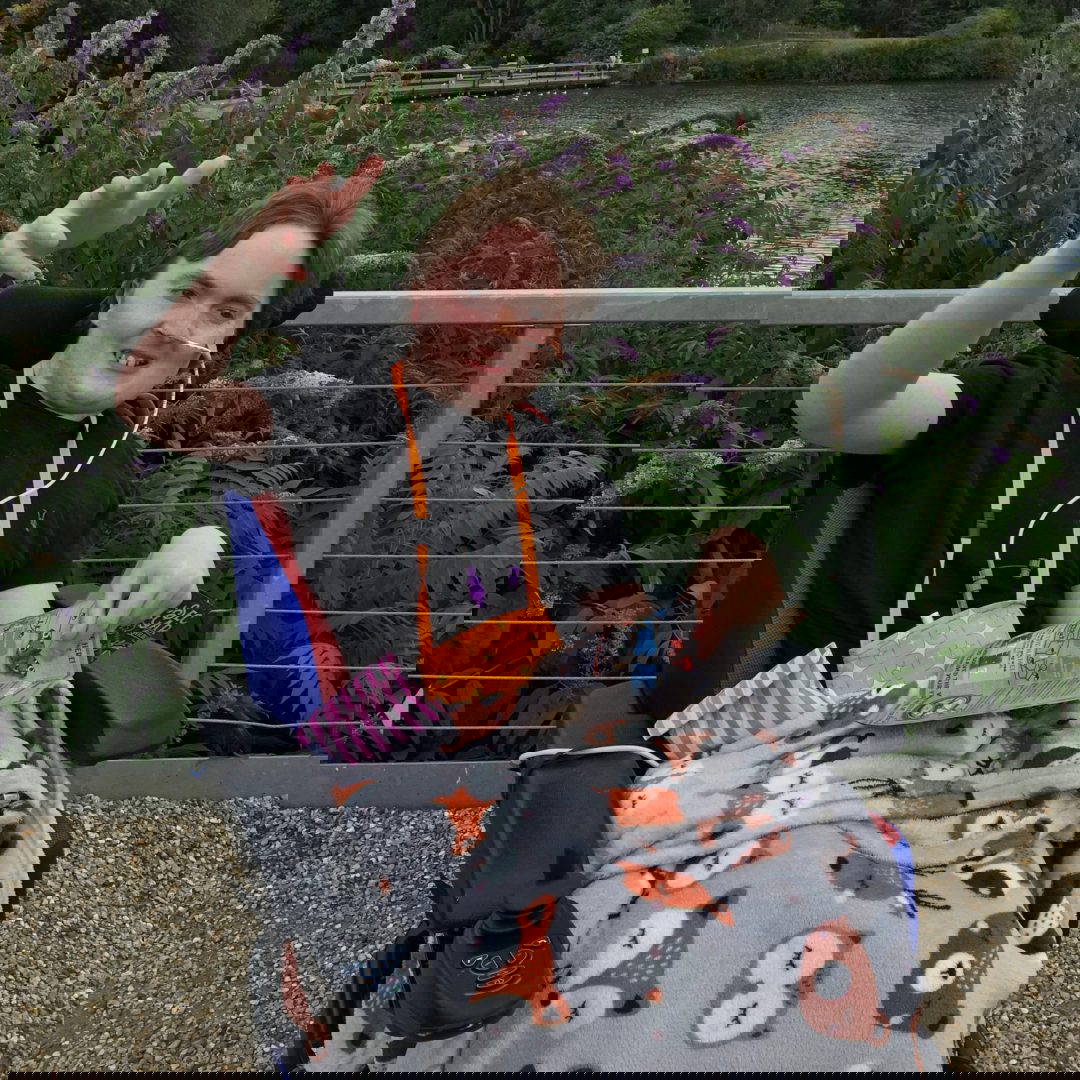 A picture of Dan, a young man, in a wheelchair, covered in a fox fleece blanket
