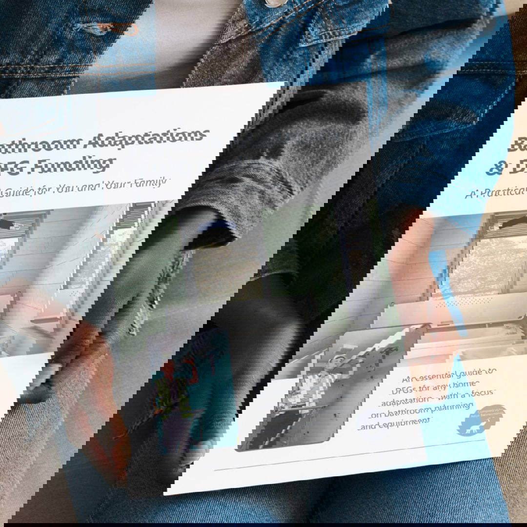 A person holding a document with a picture of an accessible bathroom and the words 'Bathroom Adaptations and DFG Funding'