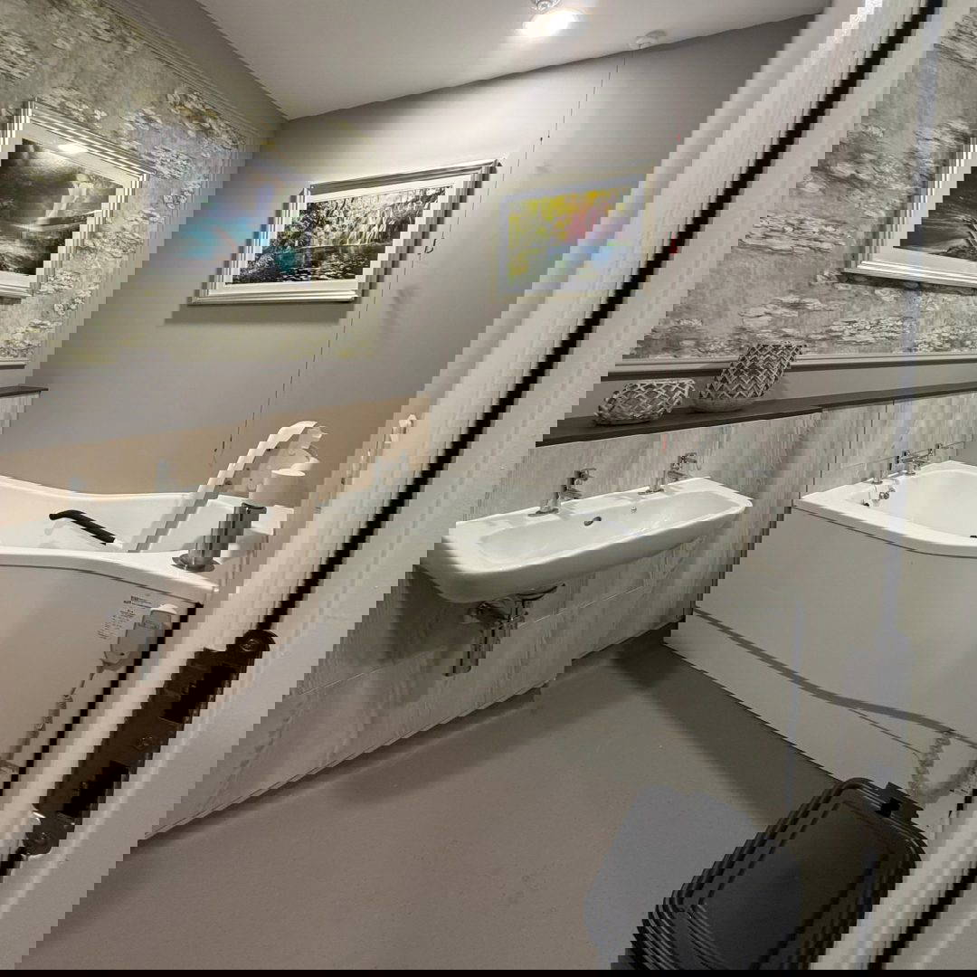 A happy girl in a Astor Bannerman ceiling hoist sling, with support from her parents,